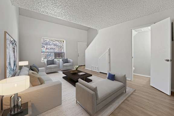 A living room with a couch, a coffee table, and a painting on the wall.