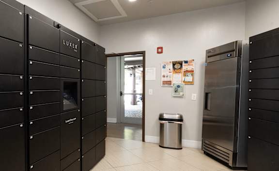 A kitchen with black cabinets and a stainless steel refrigerator.