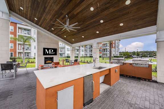 A modern outdoor kitchen with a grill and sink.