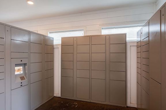 A row of lockers in a room with a white wall.