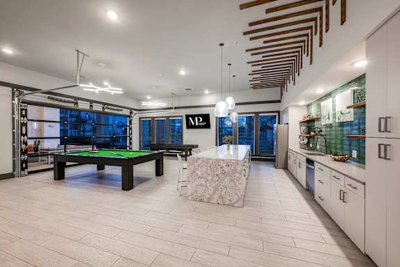 A billiard table is in the middle of a room with a pool table.