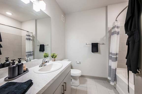 A bathroom with a white toilet, sink, and a mirror.