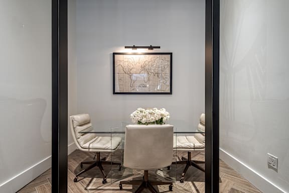 A dining room with a glass table and chairs.