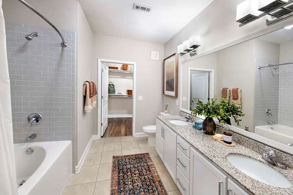 A bathroom with a white tub, sink, and toilet.