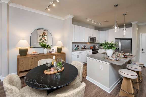 A modern kitchen with a black table and chairs.