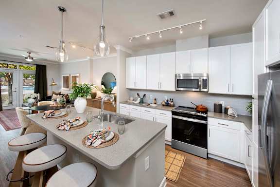 A modern kitchen with a dining table set for two.