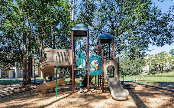 A playground with a slide, a roundabout, and a climbing frame.