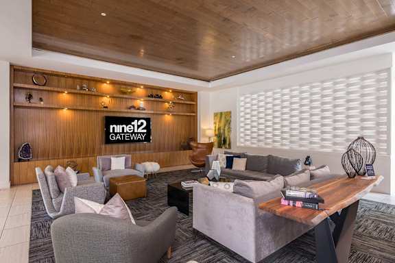 A living room with a wooden ceiling and a sign that says "nine12 GATEWAY".