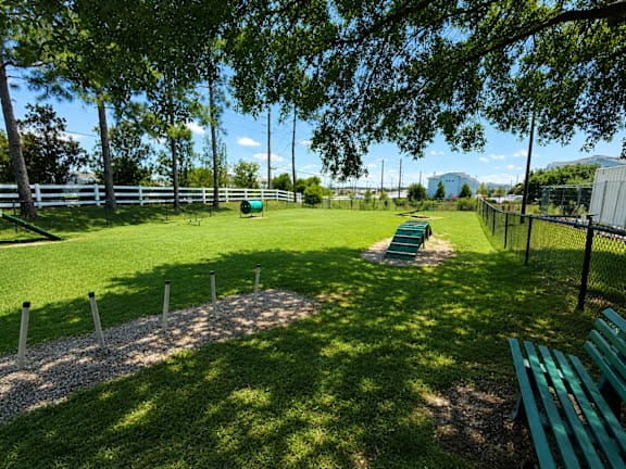 A green park with a bench and a fence.
