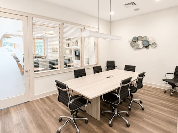 A conference room with a long table and chairs.