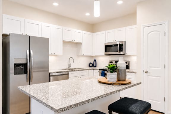 A kitchen with a granite countertop and stainless steel appliances.
