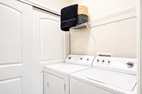 A white washing machine and dryer in a small laundry room.