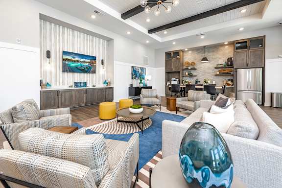 A modern living room with a white sofa and a grey and white patterned chair.