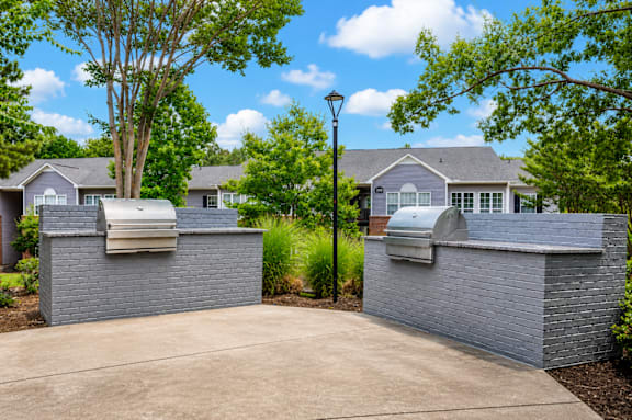 A house with a driveway and a tree in front of it.