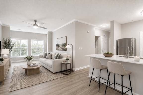A modern living room with a white sofa, a coffee table, and a bar area with stools.