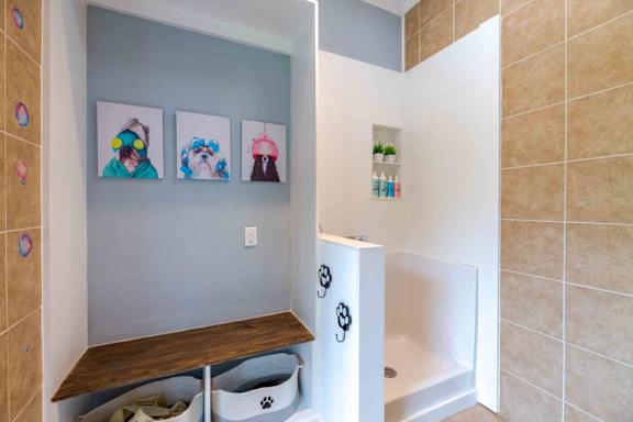 A bathroom with a white tub and a wooden bench.