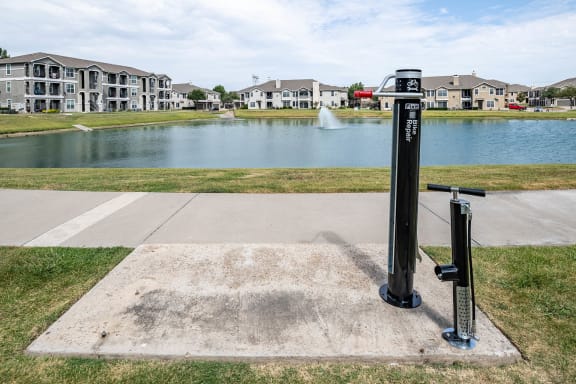 a pump in front of a pond with houses in the background  at Orion Prosper, Prosper, TX