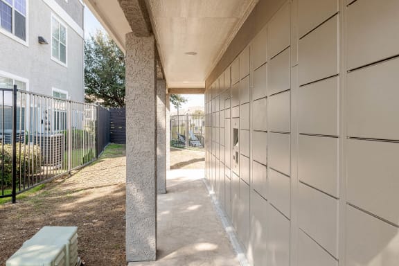 a walkway leading to a building with a fence and a bench  at Orion Prosper, Prosper