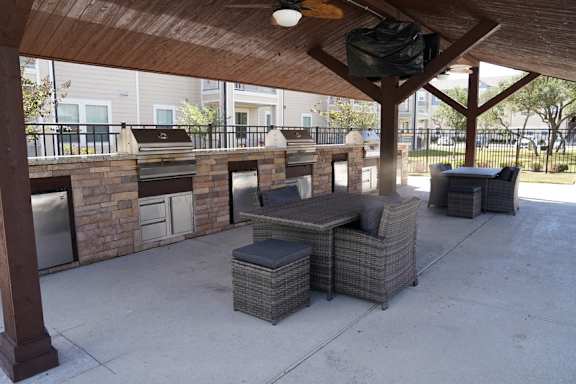 a covered patio with a grill and a seating area