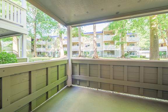 A balcony with a railing and a view of apartment buildings.