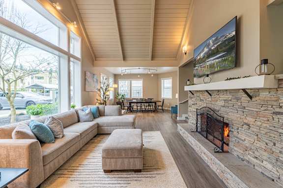 A living room with a stone fireplace and a large couch.