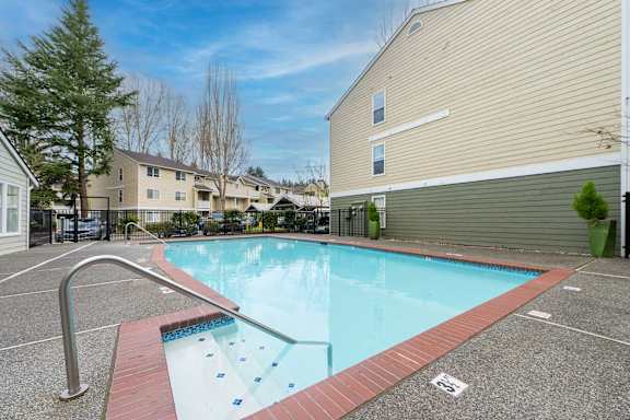 A small pool with a red border and a metal handrail.