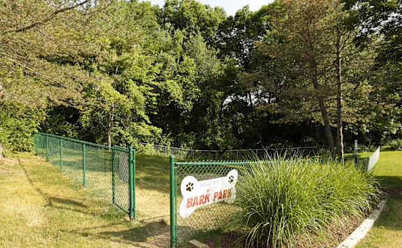 A sign for a park is on a green fence at Winchell Way Apartment , Kalamazoo, Michigan