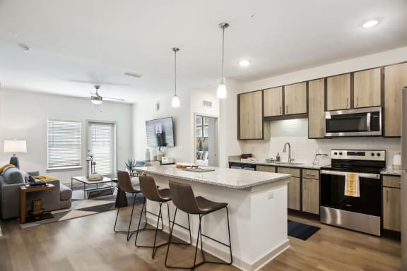 an open kitchen and living room with an island and stools