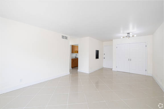 A spacious room with white walls and a tiled floor.