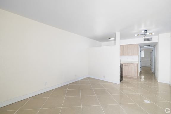 A room with a tiled floor and a doorway leading to another room.