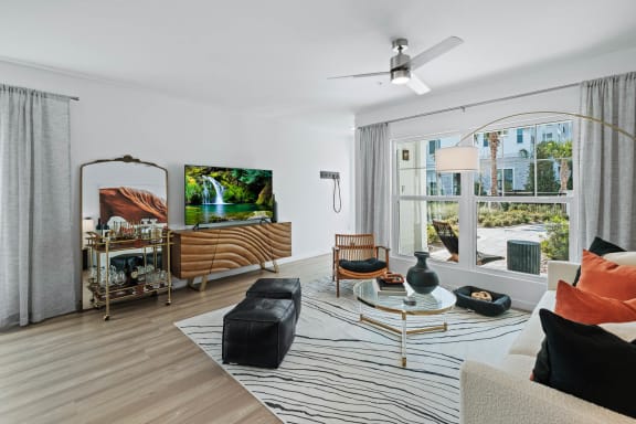 a living room with a couch and a table and a large window at Altis Grand Suncoast, Land O&#x27; Lakes Florida