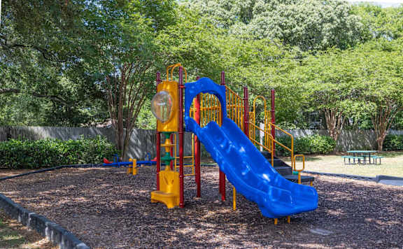 A playground with a blue slide and a yellow structure.