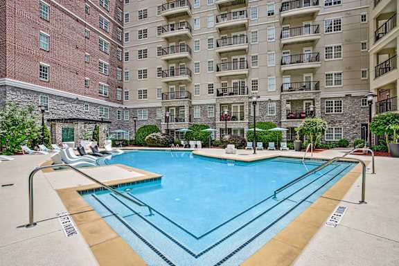 A large swimming pool in front of apartment buildings.