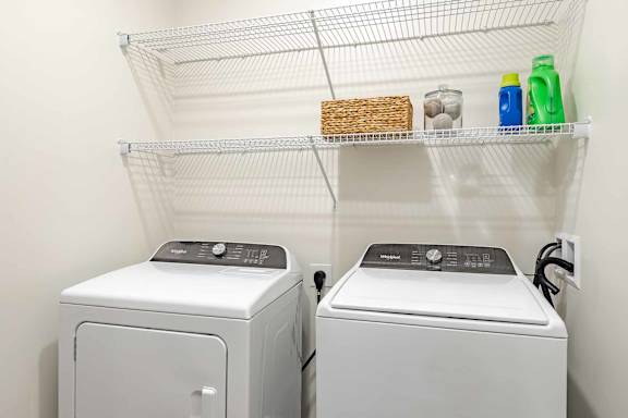 Two front loading washing machines in a laundry room.