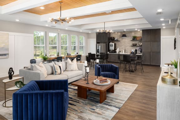 a living room with blue couches and chairs and a table