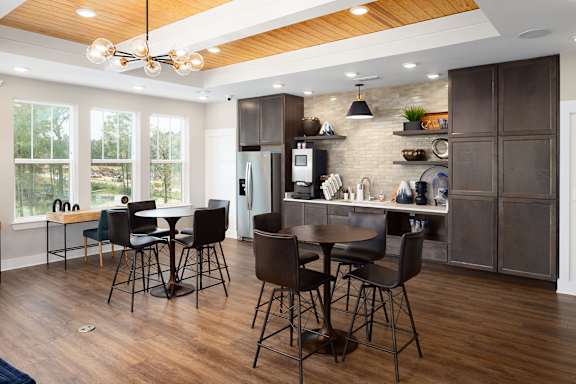 A kitchen with a table and chairs.