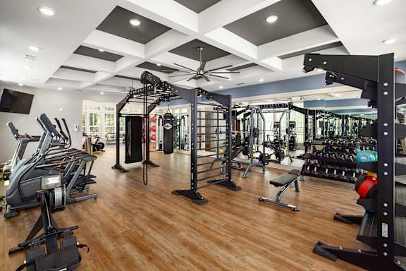 A gym with a variety of equipment including treadmills, weights, and exercise machines.