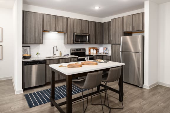 a kitchen with stainless steel appliances and a table with three cookies