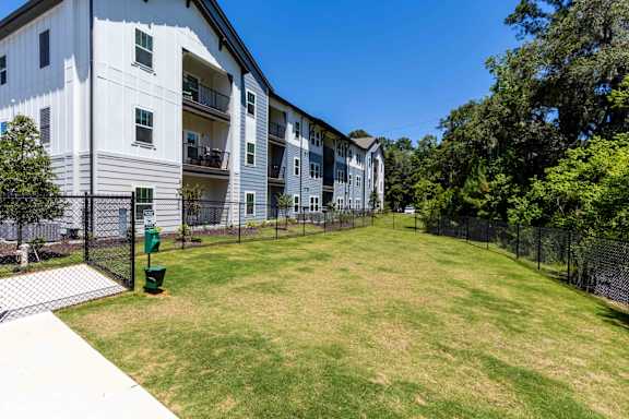 A large grassy area in front of a white apartment building.