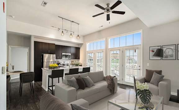 A modern living room with a kitchen in the background.