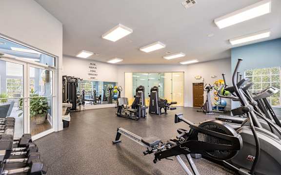 A gym with treadmills, elliptical machines, and other exercise equipment.
