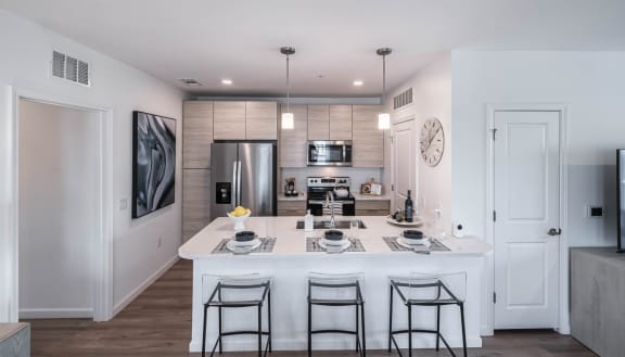 a kitchen with a large island and a stainless steel refrigerator at Altis Grand Lake Willis, Orlando, FL