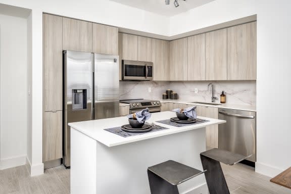 a kitchen with a white counter top and a stainless steel refrigerator at Regatta at New River, Fort Lauderdale, FL