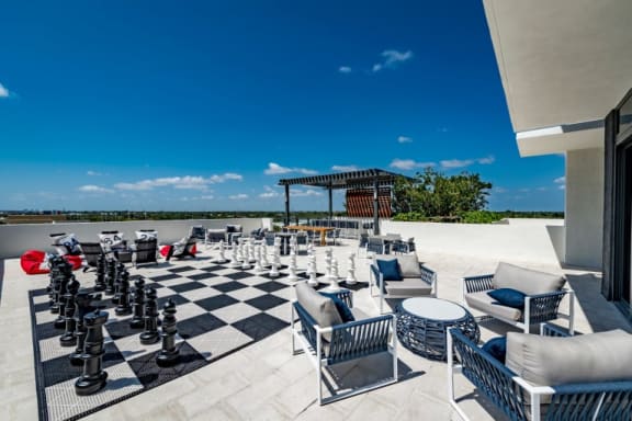 an outdoor patio with chess pieces and lounge chairs at Regatta at New River, Fort Lauderdale, 33301