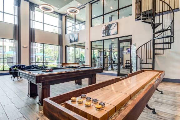 a game room with a pool table and a spiral staircase