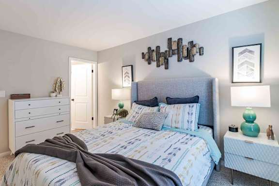A bedroom with a large bed and a dresser.