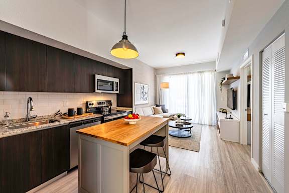 A modern kitchen with dark wood cabinets and a wooden island.