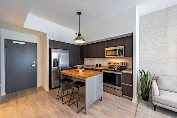 A modern kitchen with a breakfast bar and a couch.