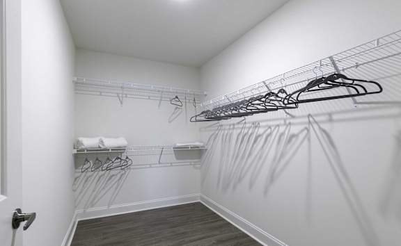 A white closet with a white door and a white towel on a shelf.