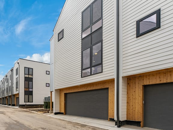 A row of modern houses with wooden garage doors.